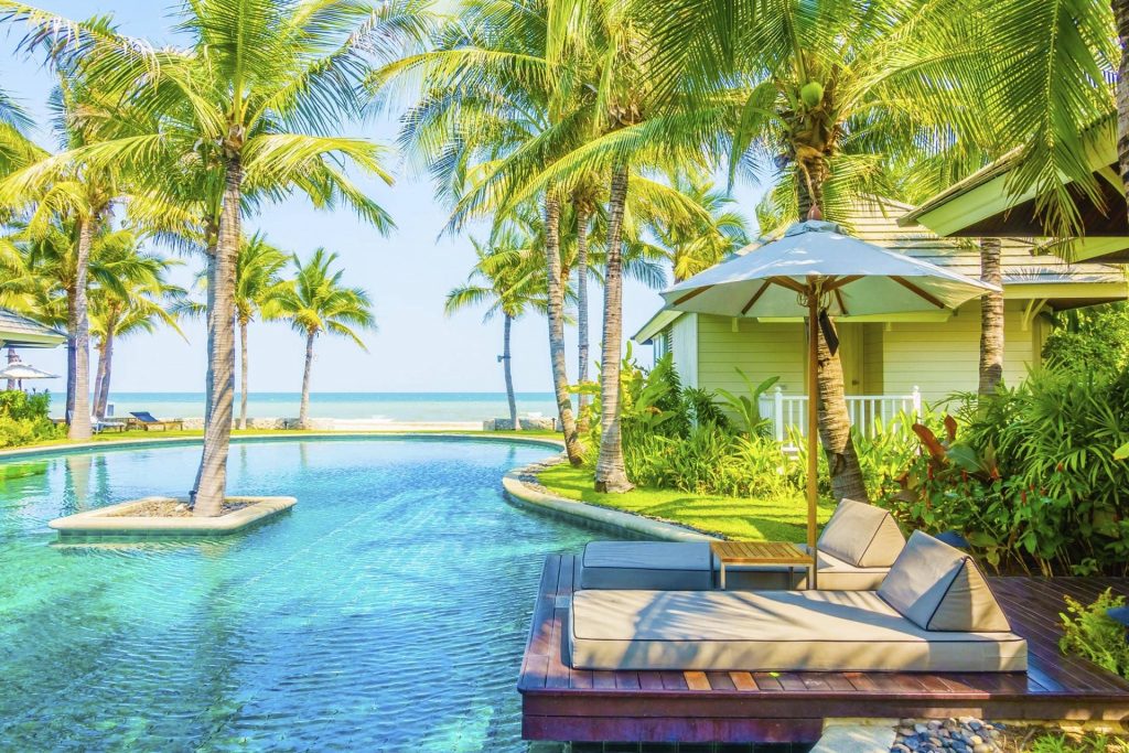 séjour paradisiaque transat en bord de piscine et palmiers